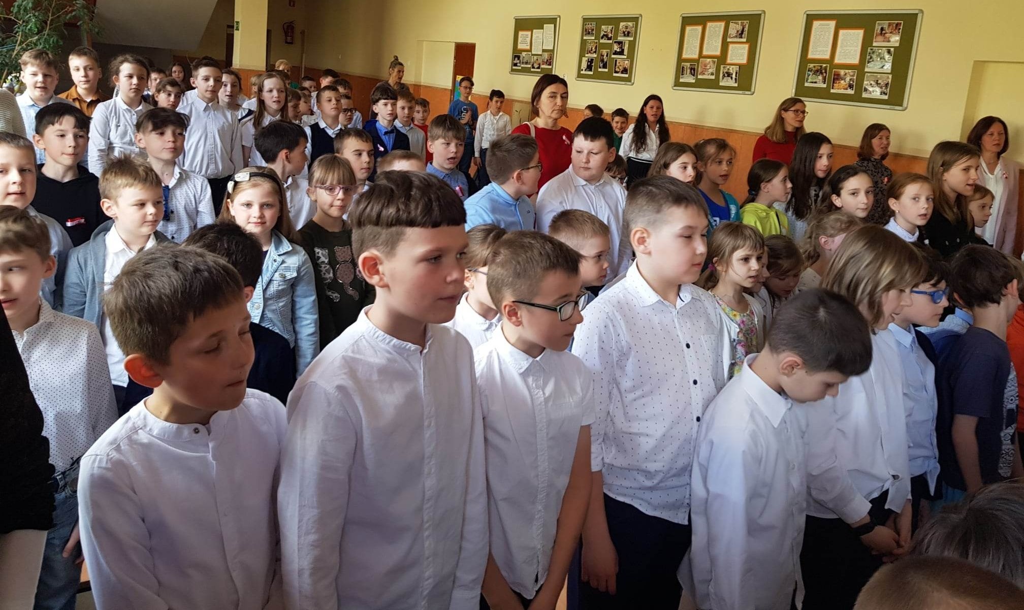 uczniowie podczas hymnu na akademii szkolnej