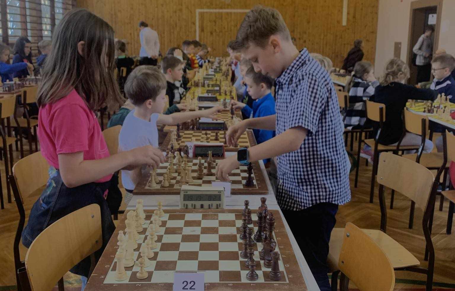 uczniowie ustawiają pionki na szachownicy
