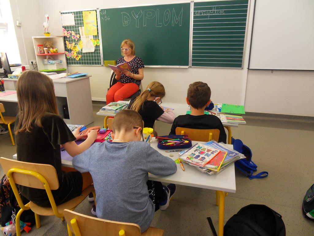Wychowawca czyta książkę swojej klasie