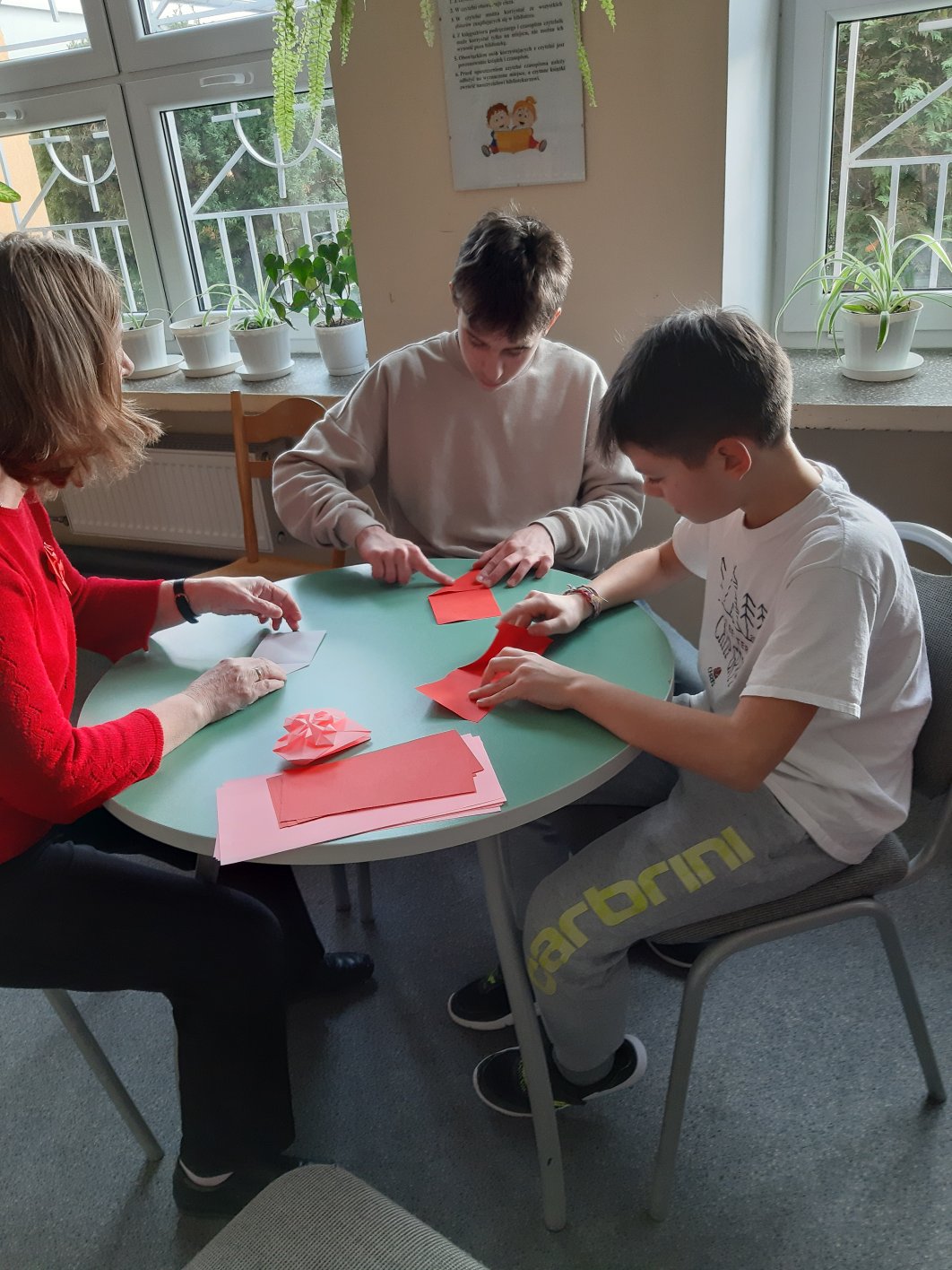 uczniowie wykonują serca papierowe techniką origami